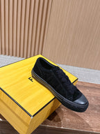 Black suede slip-on shoes with round toe and visible stitching along the upper