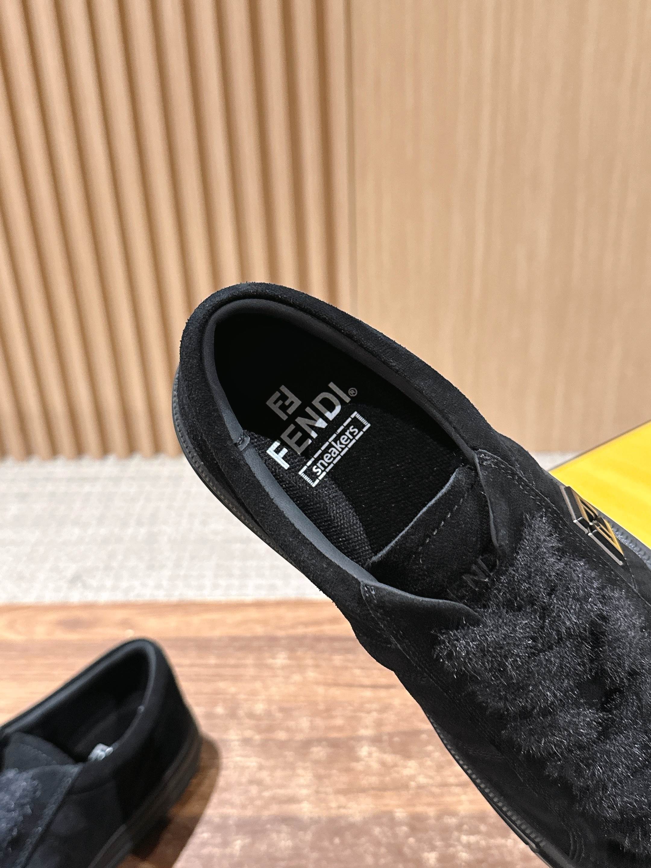 Black suede slip-on shoes showing interior lining and branding on the insole