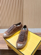 Brown suede low-top sneakers with fuzzy laces and F logo side, on yellow box