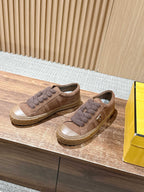 Brown suede sneakers with fuzzy laces and side zipper detail, low-top pair