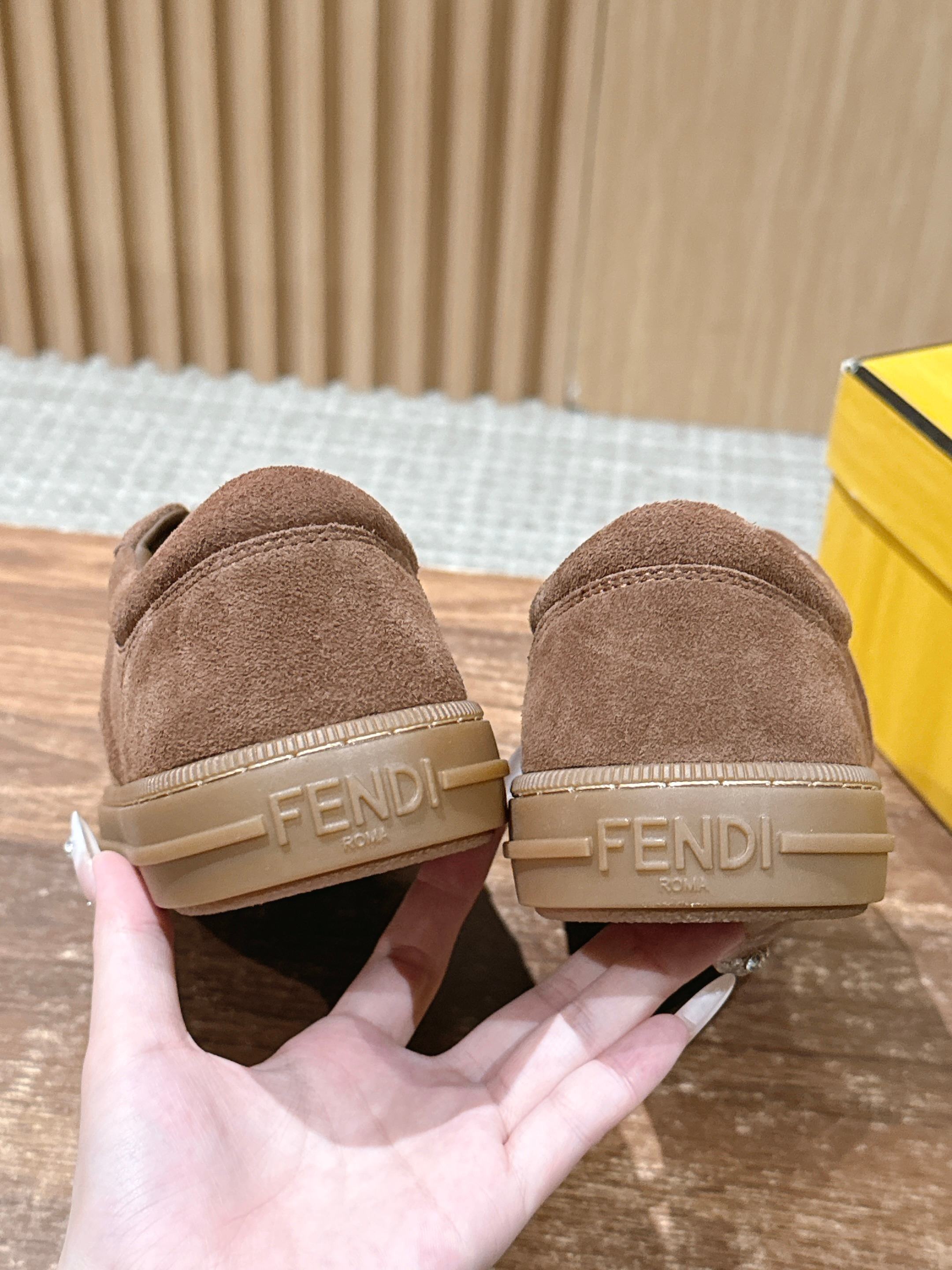 Pair of brown suede sneakers showing heel strap with Fendi logo