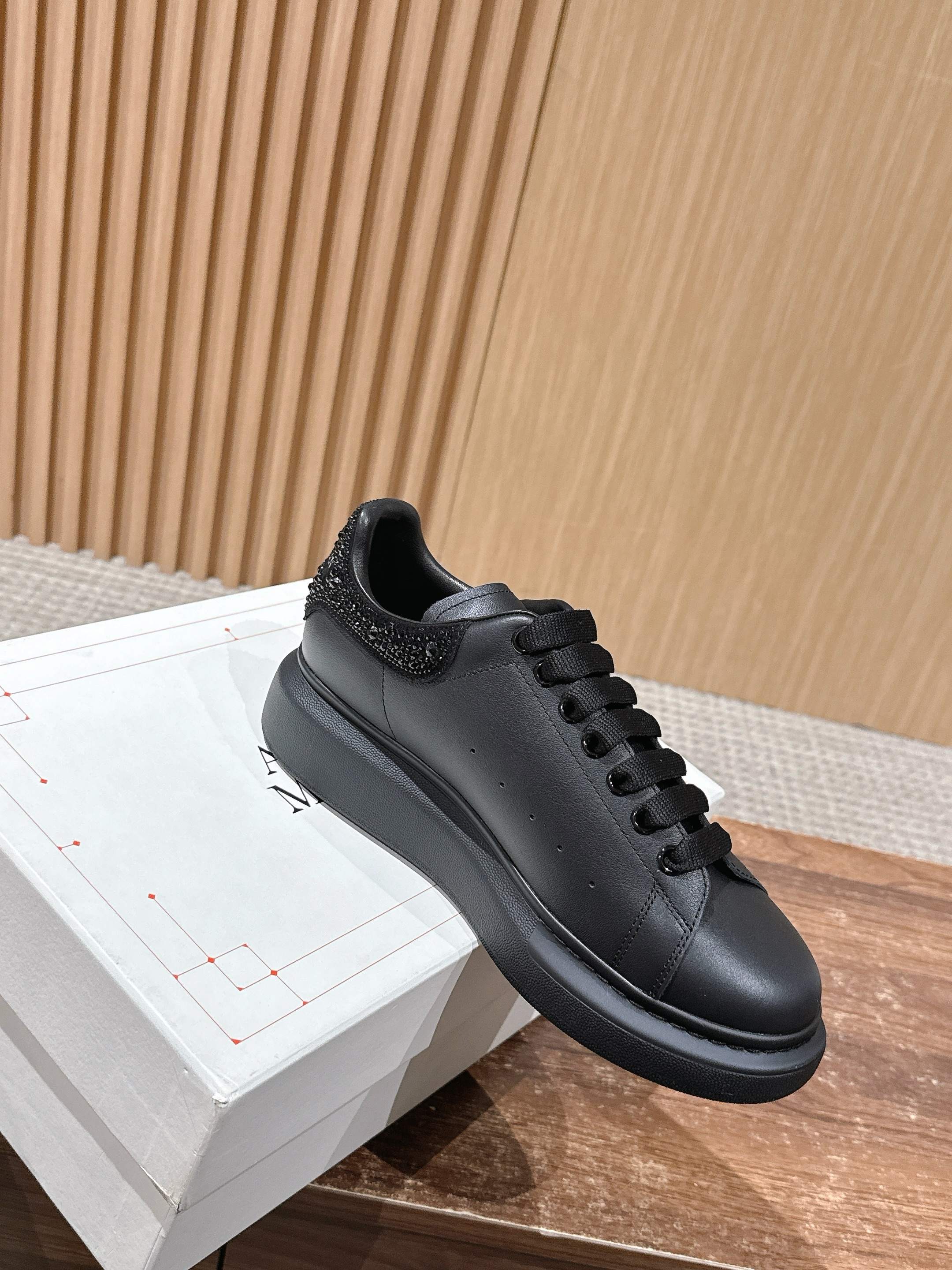Black leather lace-up sneaker with textured collar and flat rubber sole