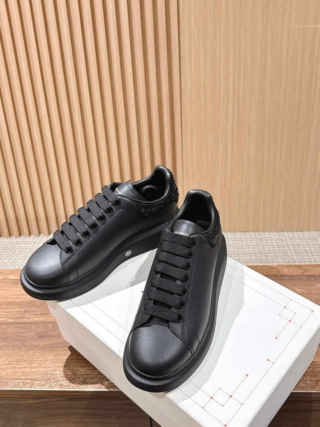 Black leather sneakers with lace-up closure and white midsole detail