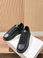 Black leather sneakers with lace-up closure and white midsole detail