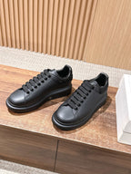 Black leather low-top sneakers with lace-up front and smooth side panel