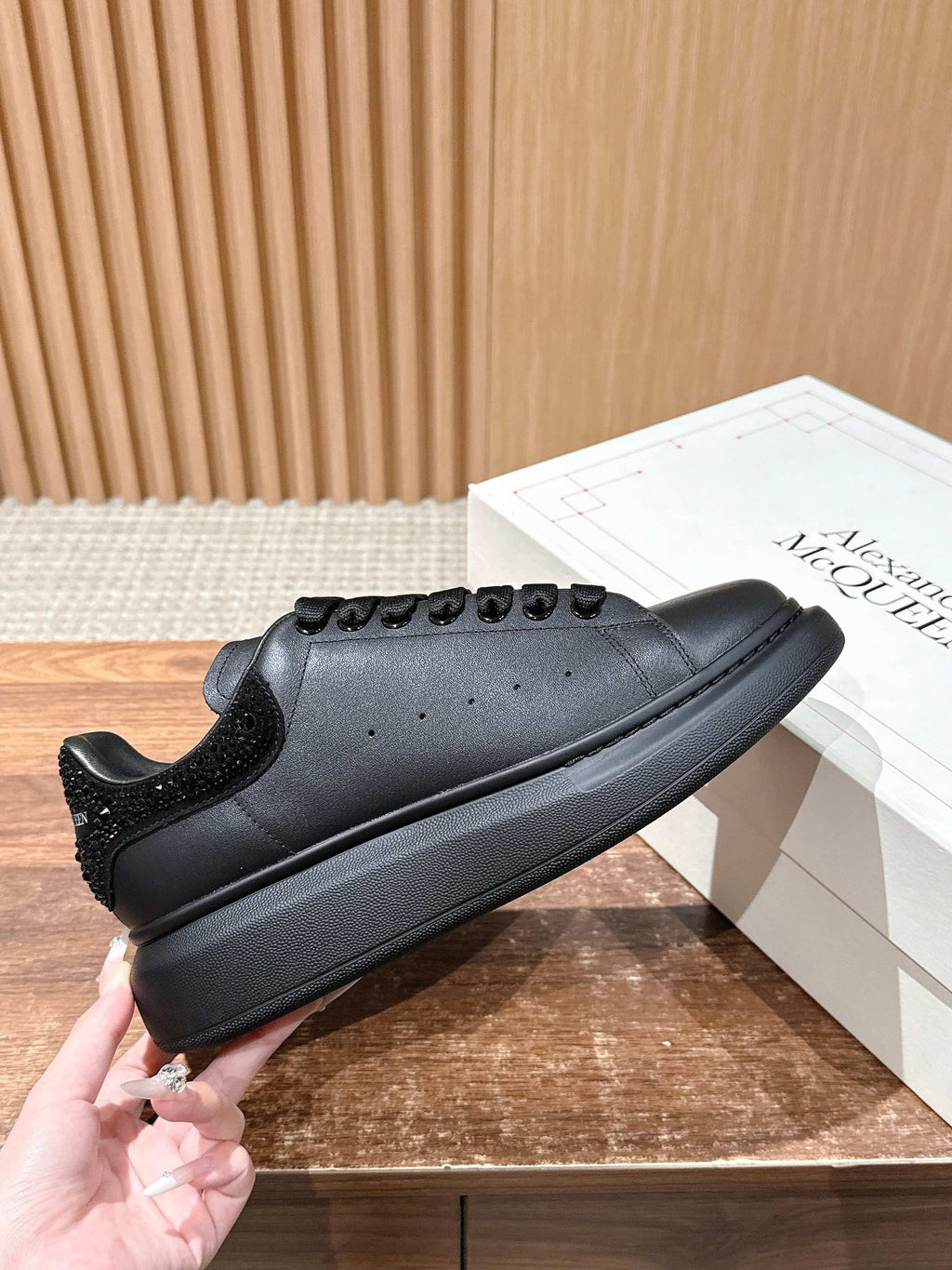 Black leather lace-up sneakers with textured heel and low-profile rubber sole