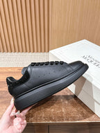 Black leather lace-up sneakers with textured heel and low-profile rubber sole