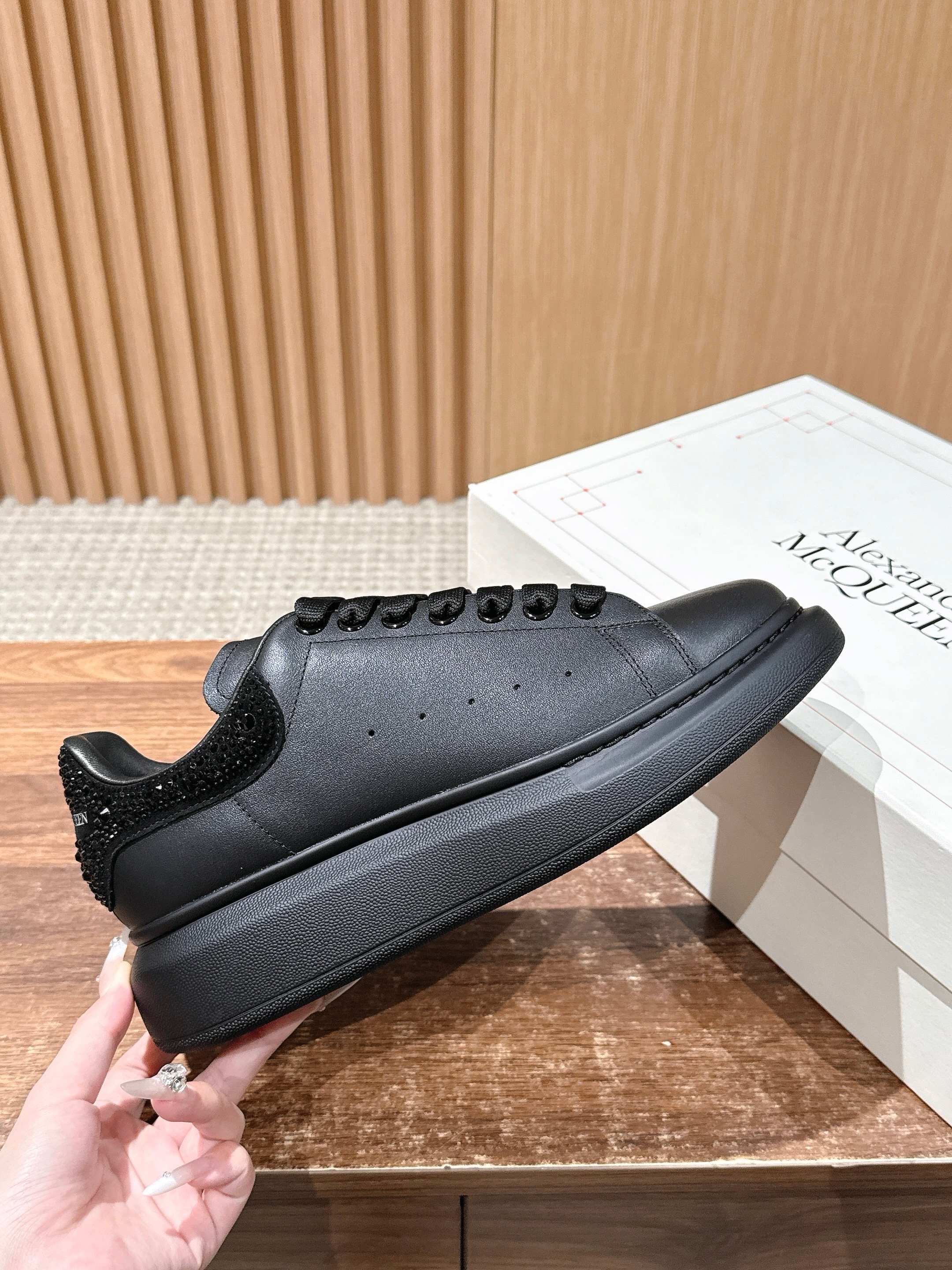 Black leather lace-up sneakers with textured heel and low-profile rubber sole