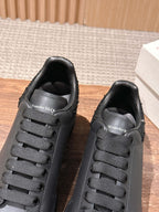 Black sneakers with lace-up eyelets and logo on the tongue