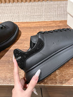 Black leather sneaker close-up with textured side panel and lace-up detail
