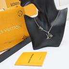 Silver charm necklace on black display bust with LV pendant