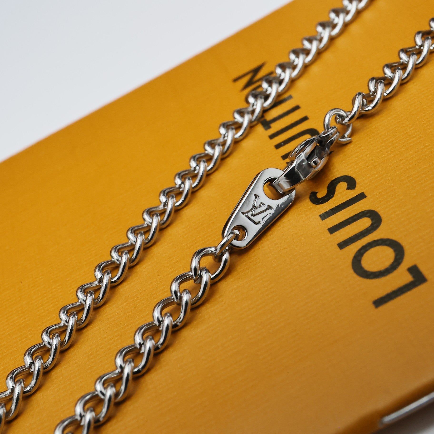Silver chain necklace with LV letter charm and small flower detail