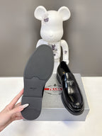 Prada unisex black loafer outsole view with ridged traction sole pattern