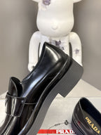 Prada unisex black leather loafer with stacked platform sole and side strap tab