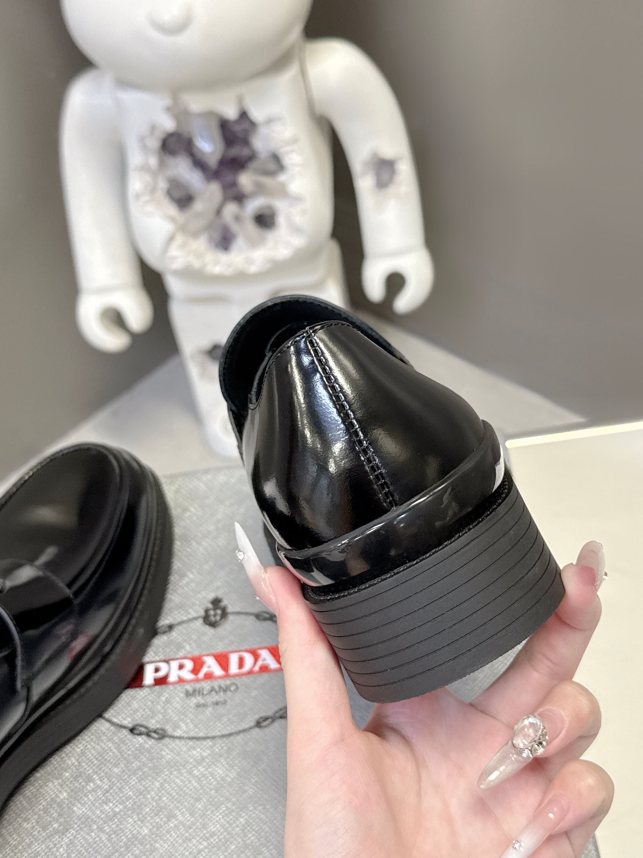 Prada unisex black leather loafer heel side view with ridged platform sole