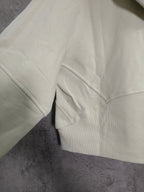 Light-colored zip-up hoodie with front seam pocket and ribbed cuffs