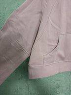 Light pink zip-up hoodie side view with ribbed cuffs and kangaroo pocket