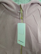 Zip-up hoodie close-up with green zipper and small lululemon neck label