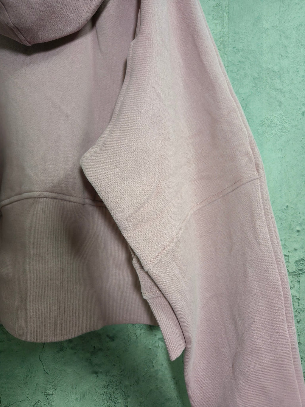 Light pink hoodie sleeve and side pocket detail with ribbed cuff