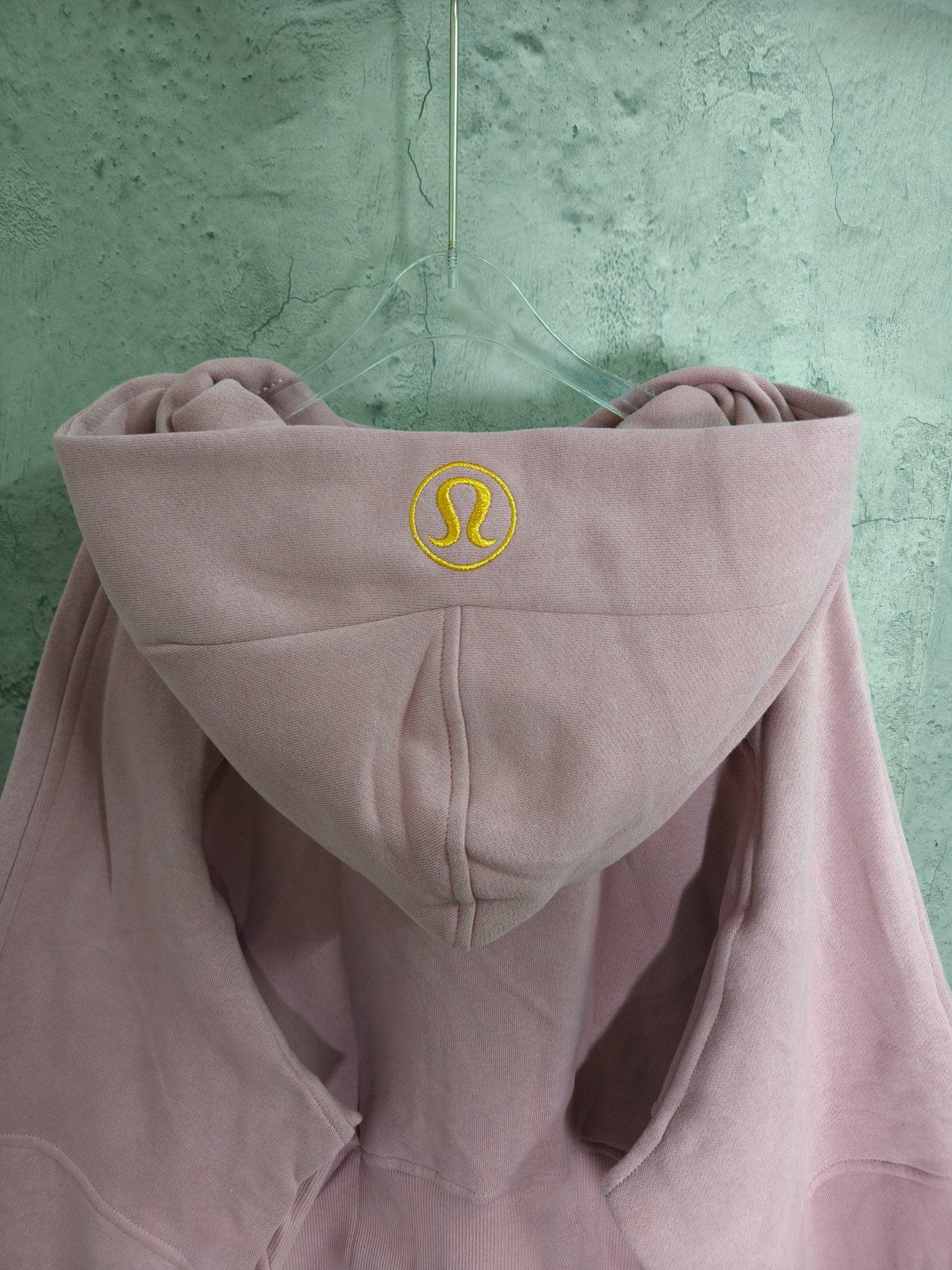 Light pink hoodie with logo on hood and front zipper