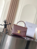 Celine top-handle bag in burgundy leather with gold logo and shoulder strap.