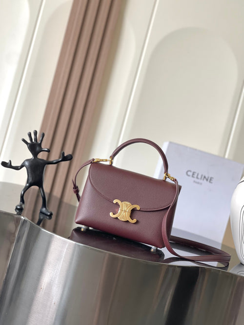 Celine top-handle bag in burgundy leather with gold logo and shoulder strap.
