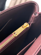 Burgundy bag interior with gold zip slider and multicolor zipper teeth.
