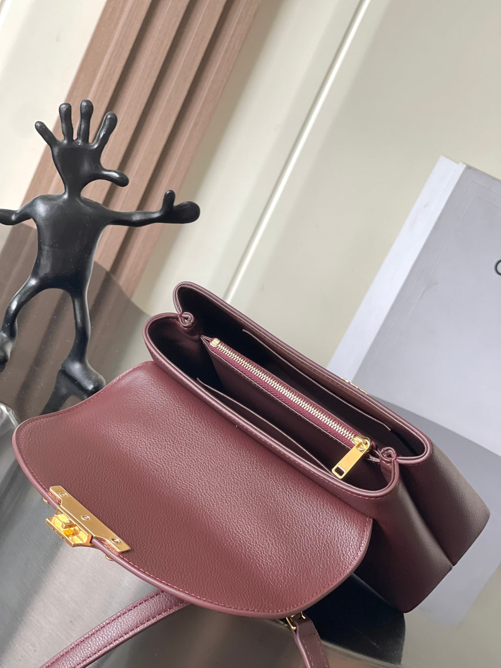Burgundy Celine bag open with zip pocket and gold zipper pull.
