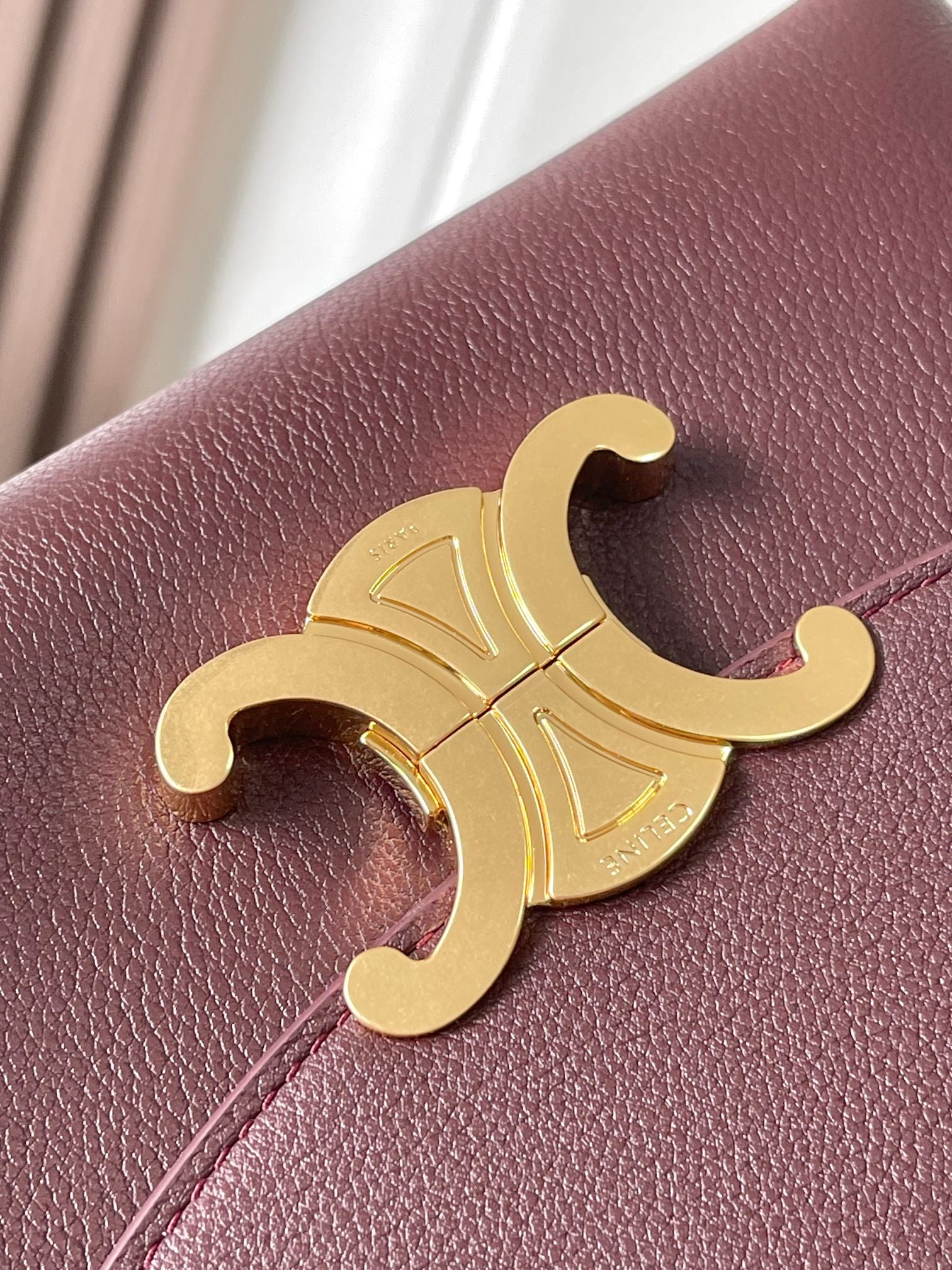 Gold C logo hardware on burgundy leather front panel.