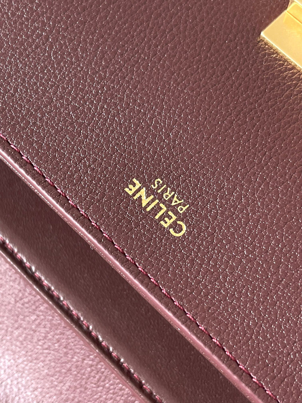 Celine Paris embossed on burgundy leather with visible edge stitching.