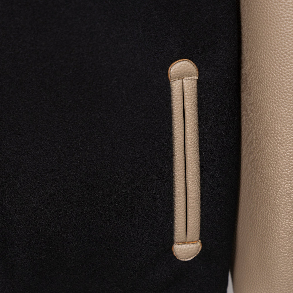 Black jacket with beige leather-style welt pocket and vertical pocket stitch