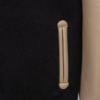 Black jacket with beige leather-style welt pocket and vertical pocket stitch