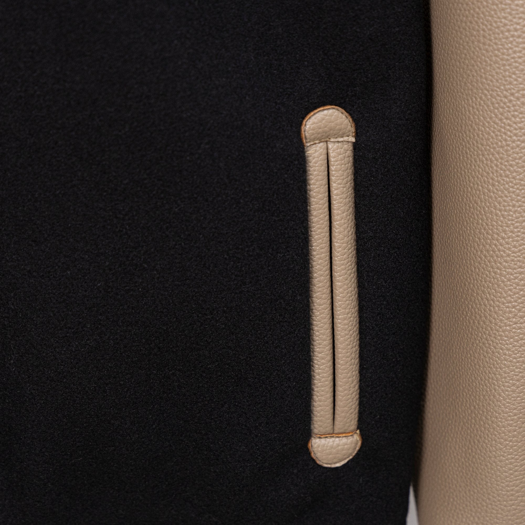 Black jacket with beige leather-style welt pocket and vertical pocket stitch