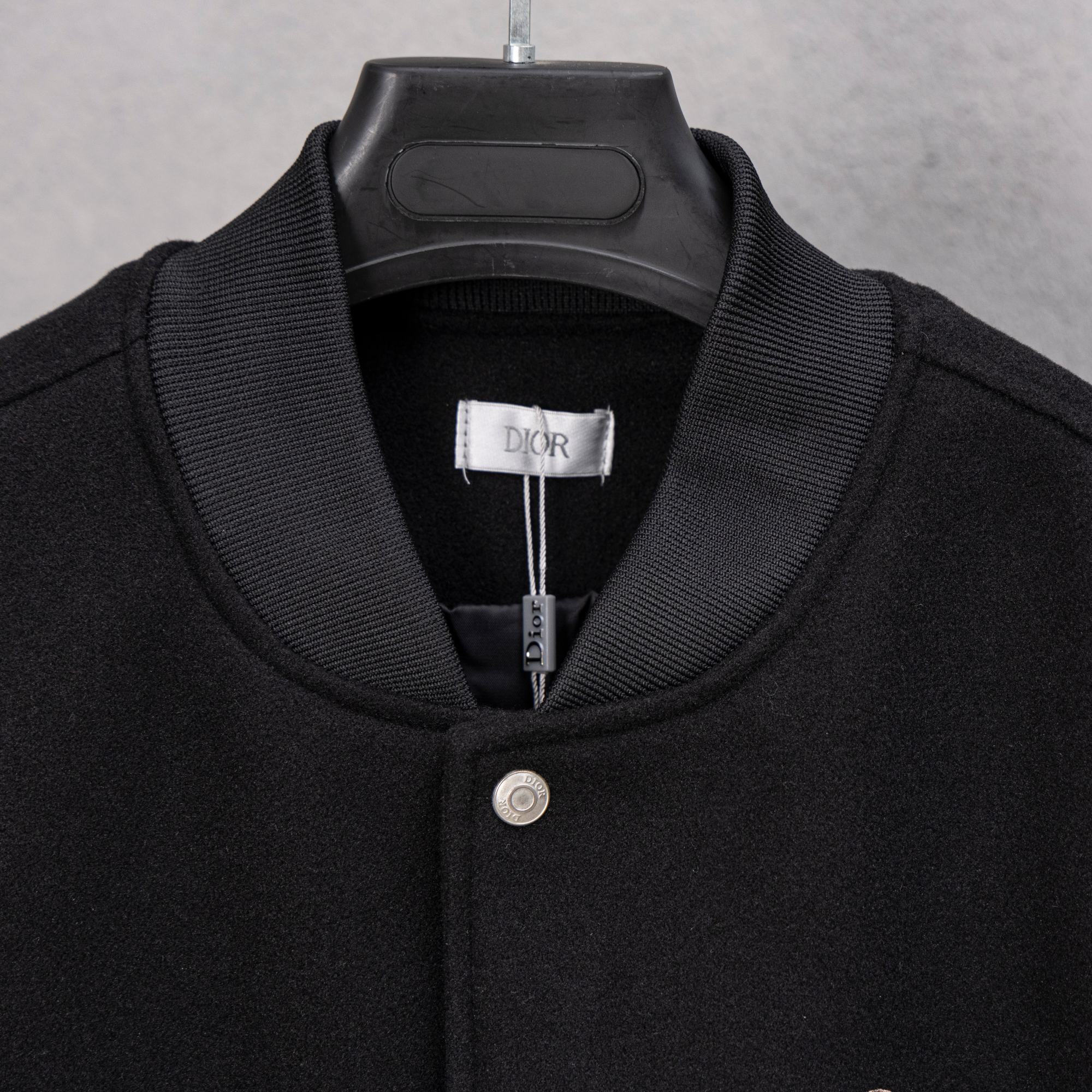 Black long-sleeve jacket with ribbed collar and DIOR label at neck