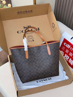 COACH tote bag, navy patterned fabric with tan leather handles, in open gift box