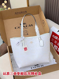 Coah tote bag in a box with long white handles and hanging tag