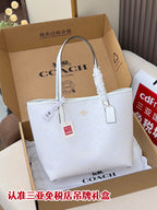 Coah tote bag in a box with long white handles and hanging tag