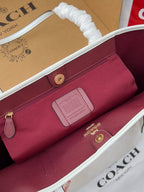 Coah burgundy zip pouch inside the tote, with logo patch and gold hardware