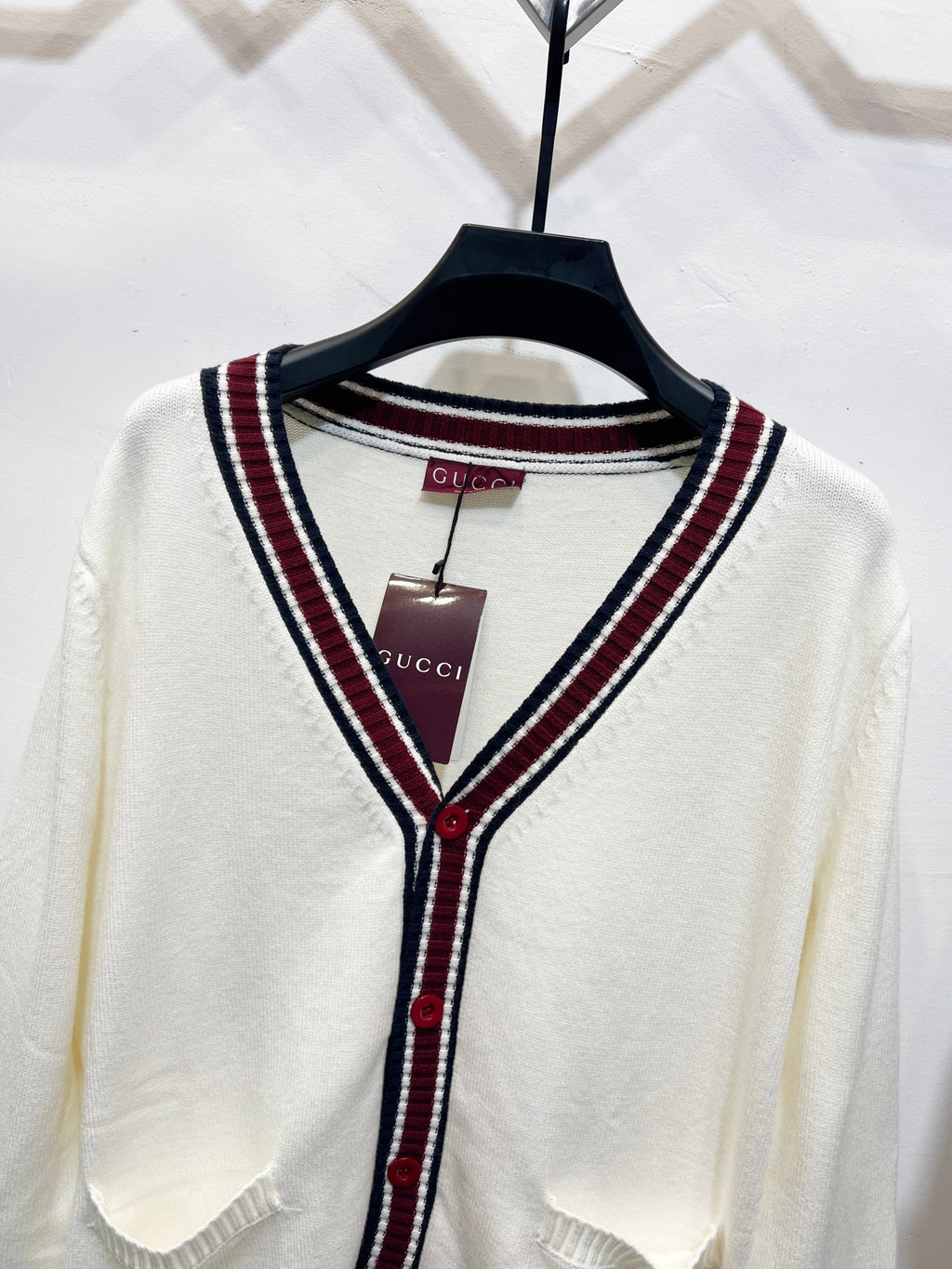 Gucci long cardigan close-up: white V-neck with maroon/navy striped trim and buttons