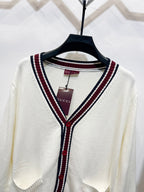 Gucci long cardigan close-up: white V-neck with maroon/navy striped trim and buttons
