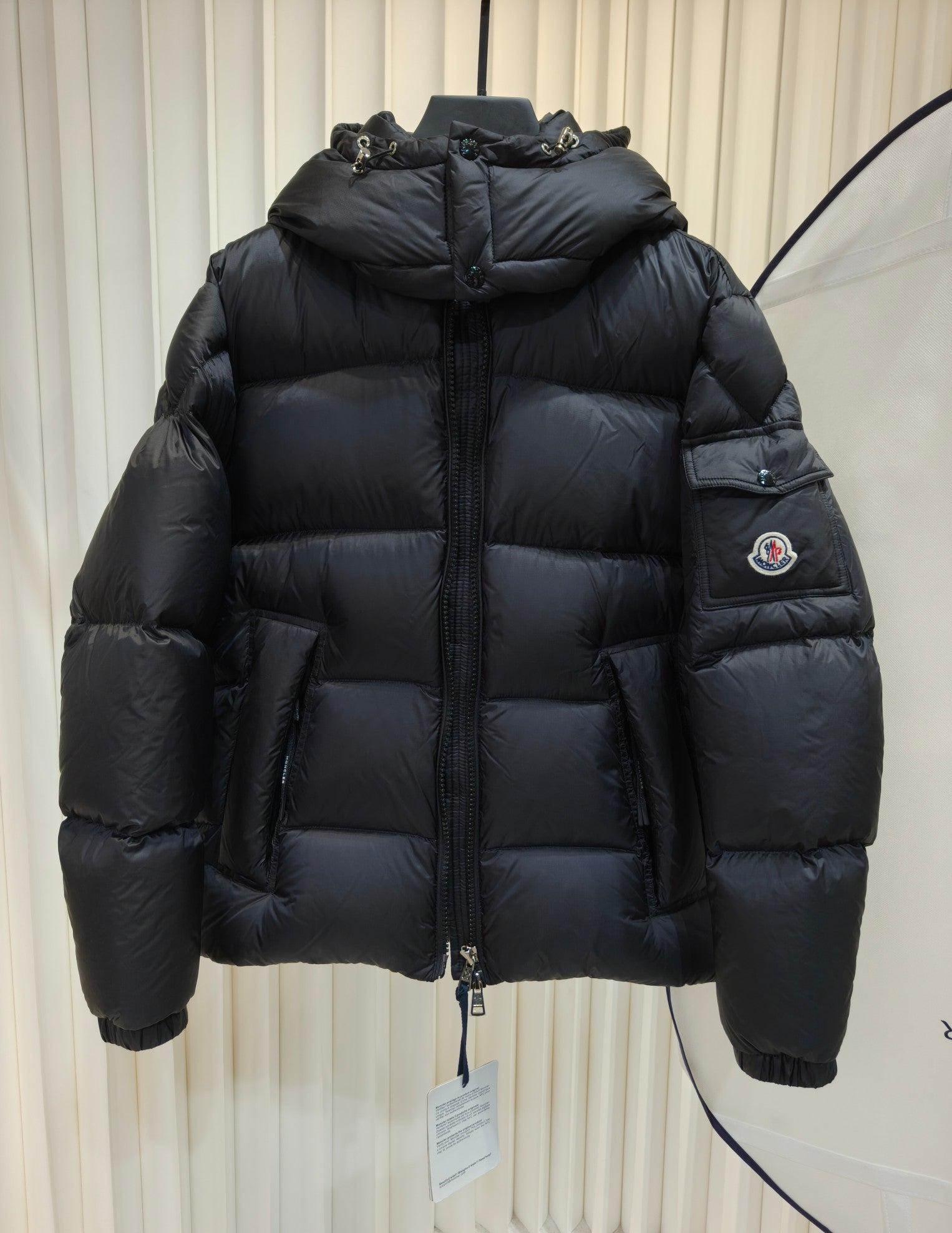 Moncler long padded jacket in dark color, quilted pattern, full-zip front, hood