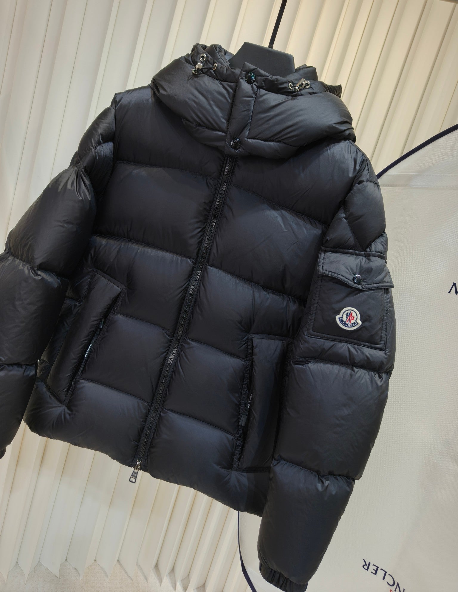 Moncler long padded jacket, dark quilted puffer with hood, full-zip front, sleeve patch