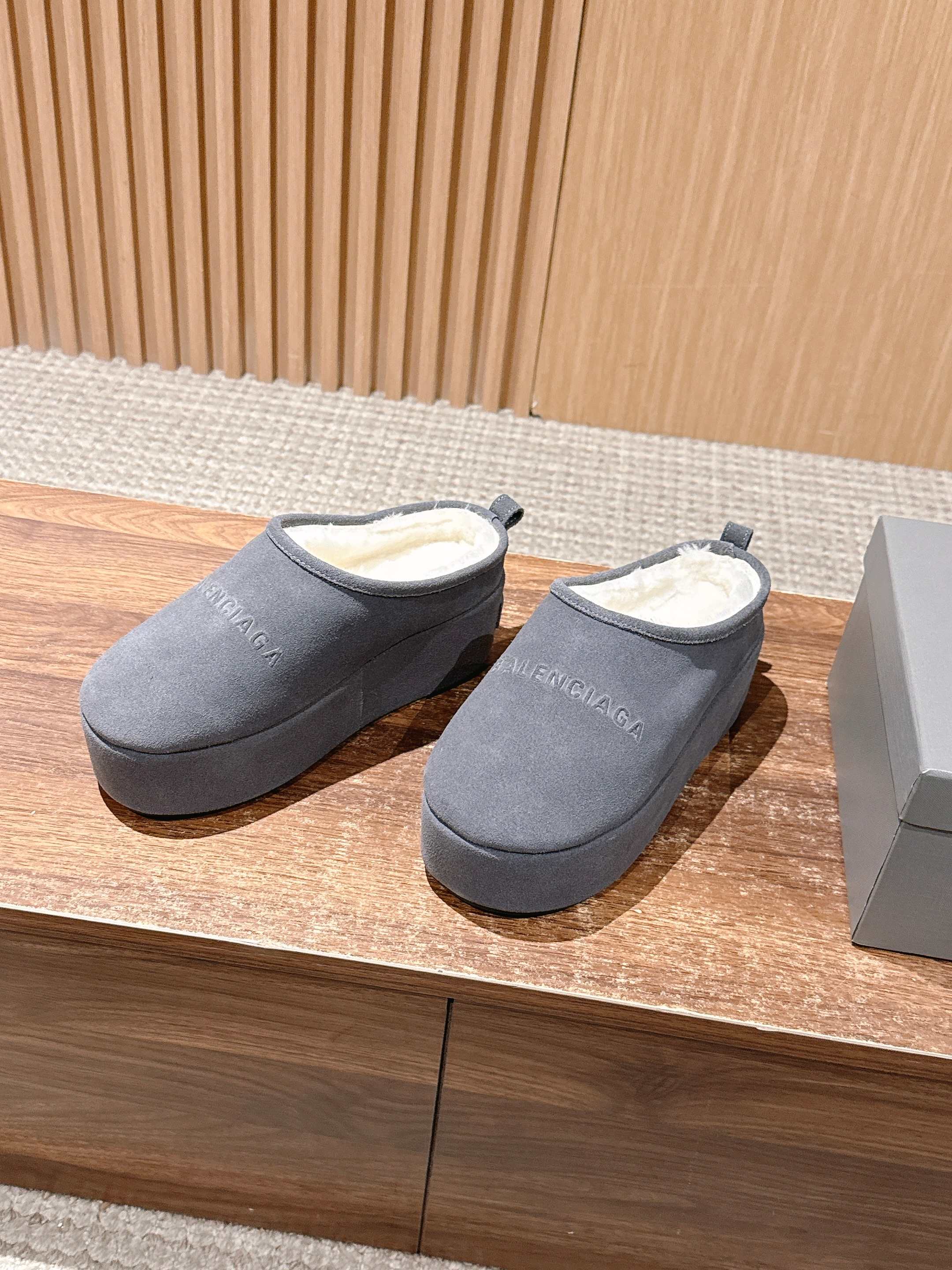 Grey Balenciaga slide sandals with open back, side view, pair on display