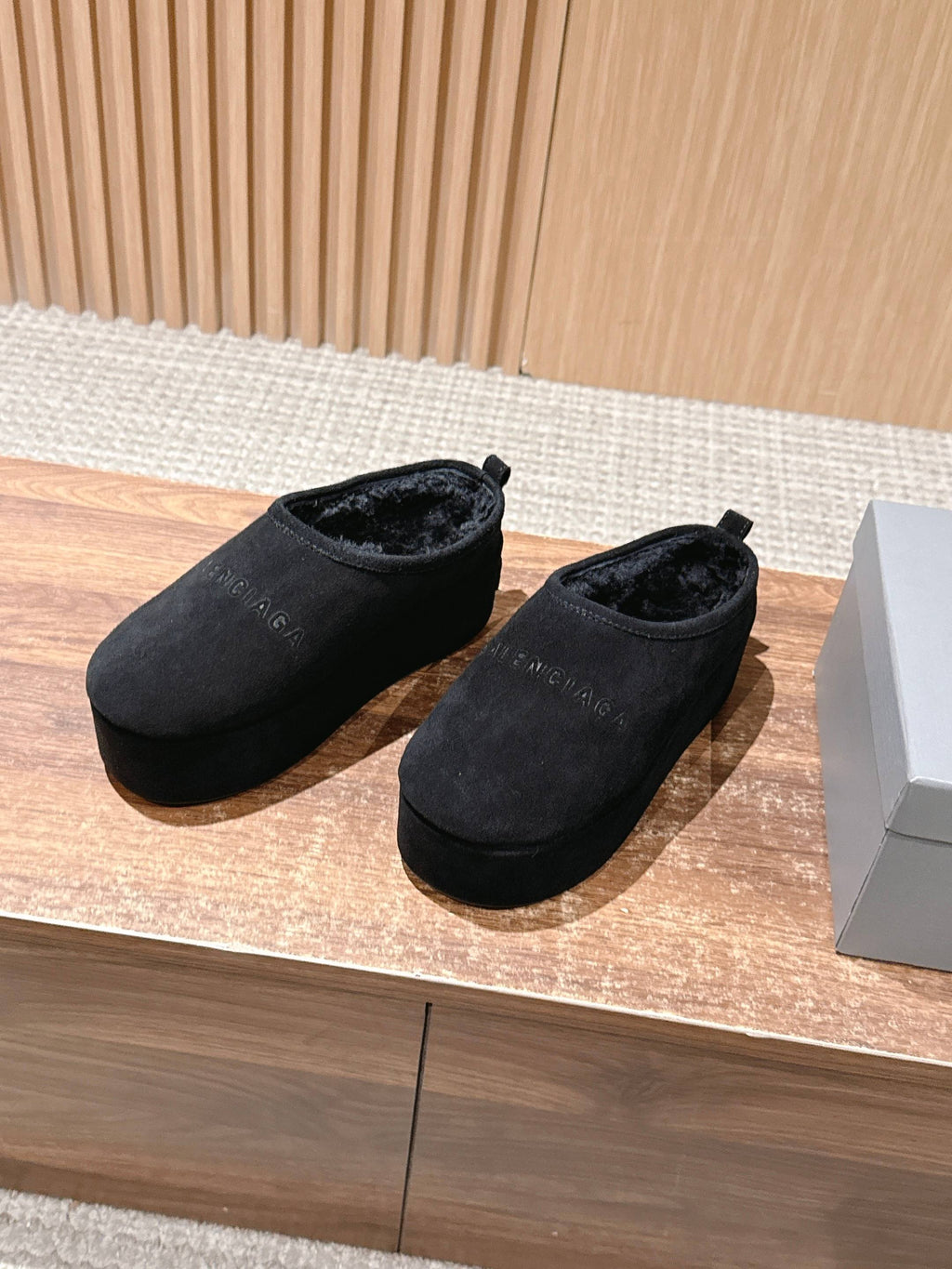Black suede slip-on mules, pair shown side by side on a display surface