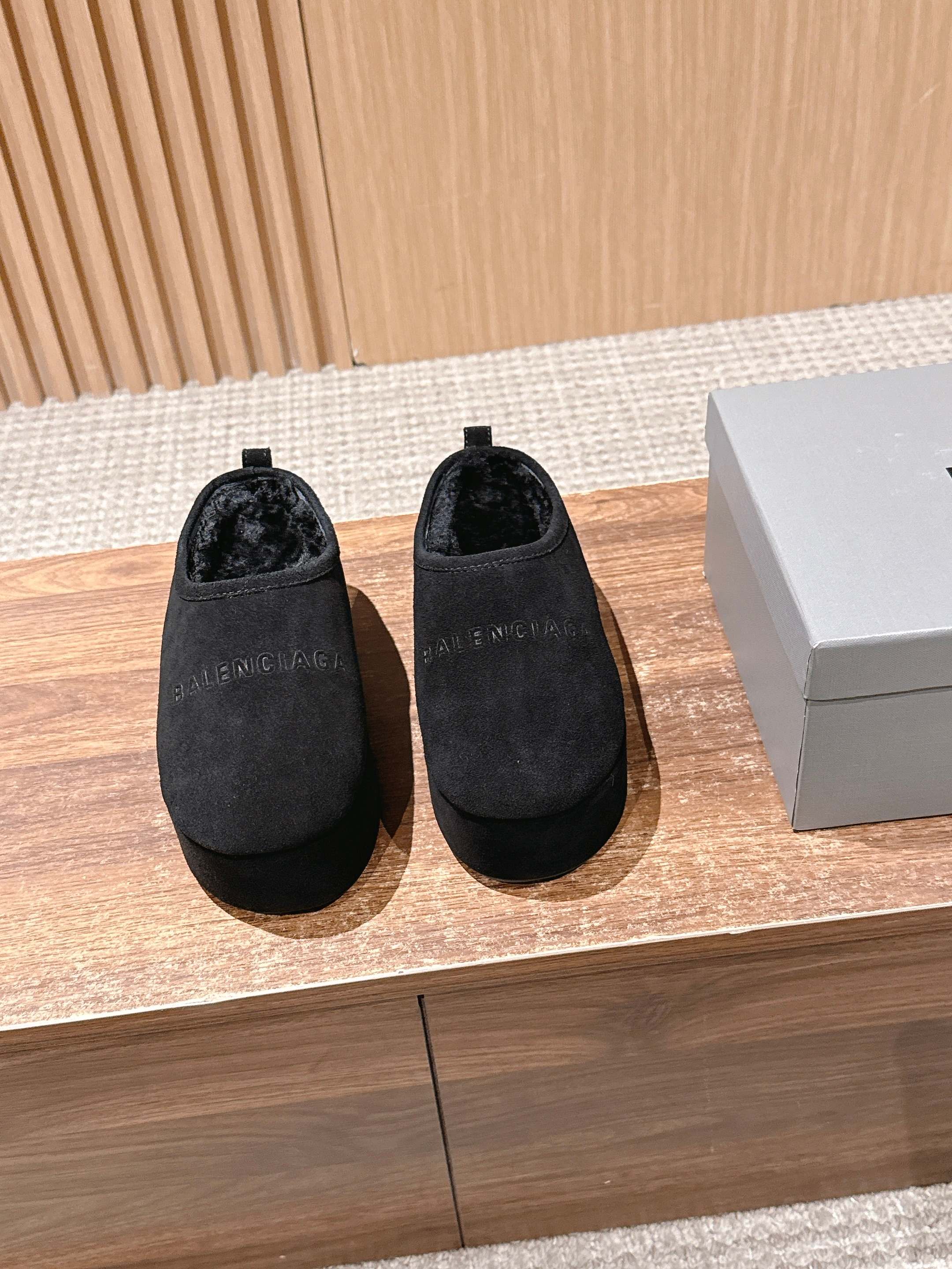 Black suede slip-on mules with rounded toe and short pull tab at back