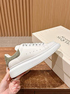 Alexander McQueen white leather sneaker with olive heel panel and lace-up closure