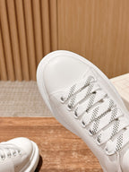 Close-up of white leather lace-up sneakers with perforated eyelets