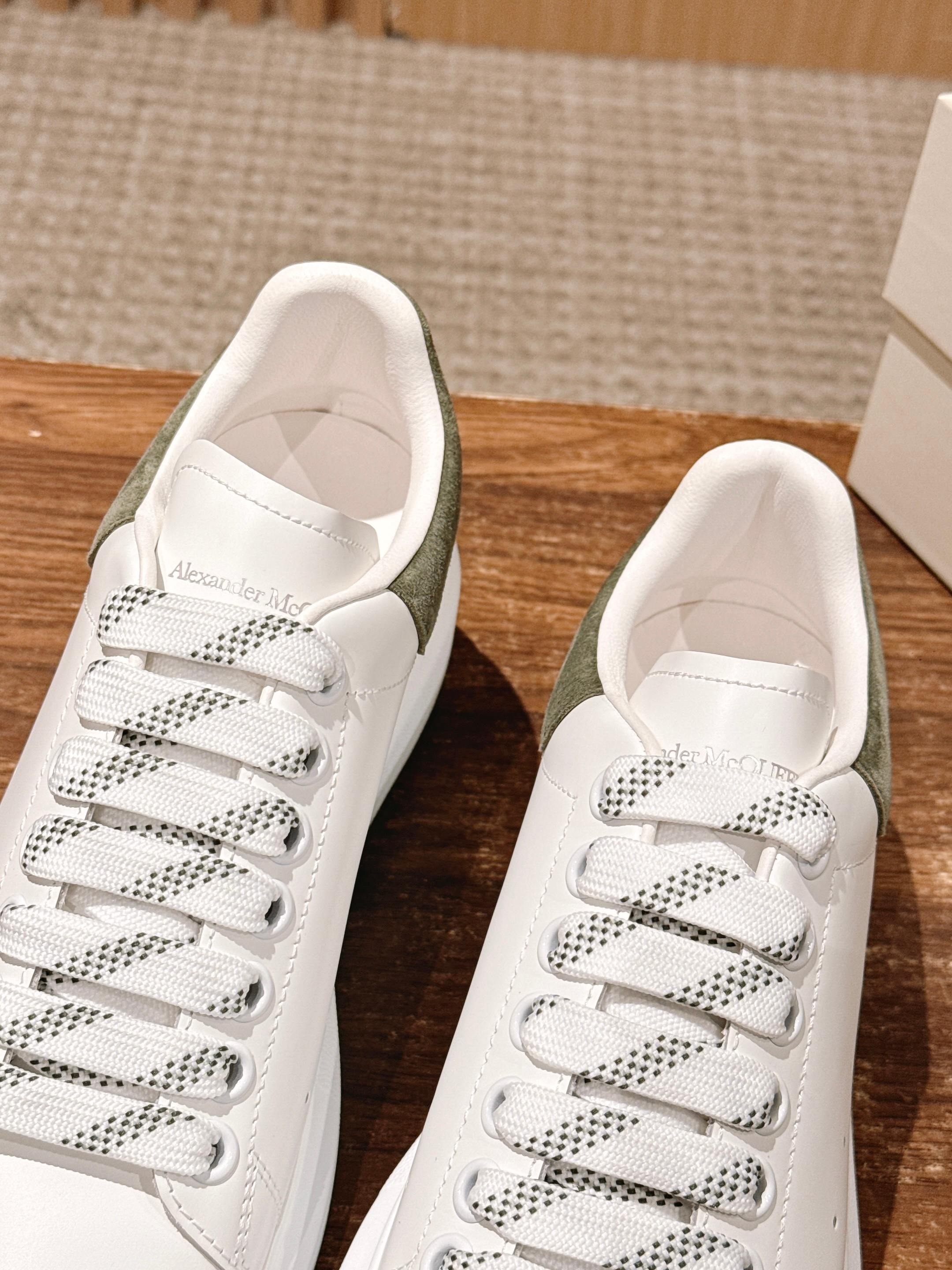White lace-up sneakers with olive heel lining and patterned lace detailing