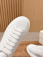 White leather sneaker toe with lace-up front and textured sole edge