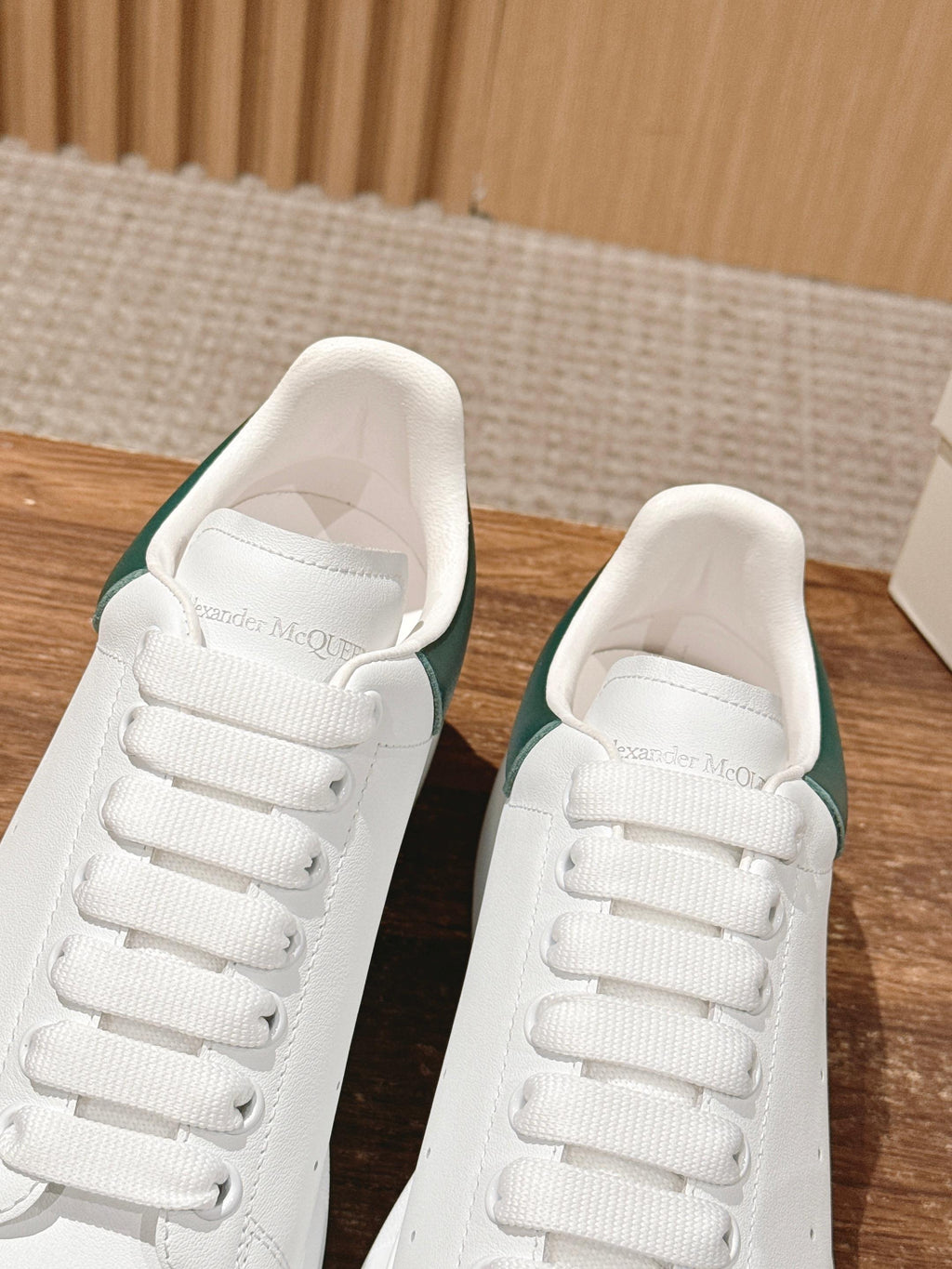 White leather sneakers with green collar lining and padded tongue